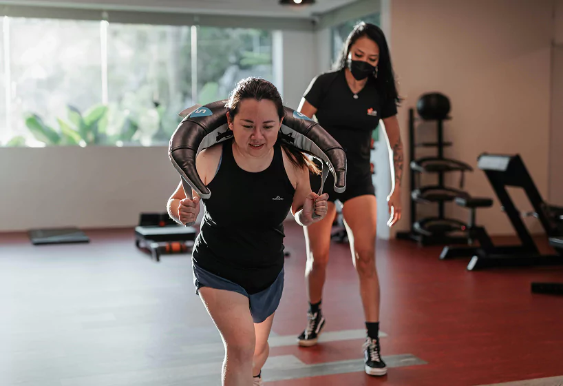 In a gym, two women are engaged in a workout