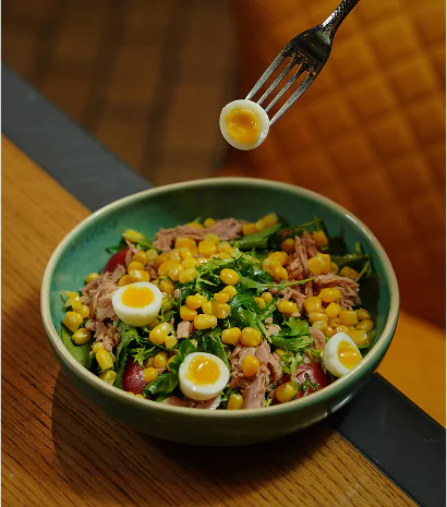 A bowl of food accompanied by a fork and a spoon, arranged neatly on a table.